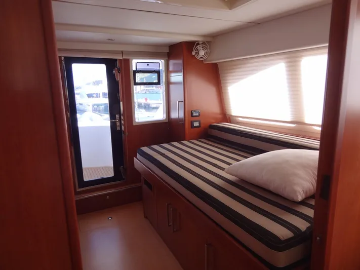 Dalliance Yacht Photos Pics 2014 Leopard 58 yacht interior cabin with striped bedding and wooden finishes
