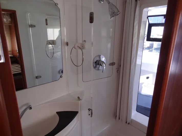 Dalliance Yacht Photos Pics 2014 Leopard 58 yacht bathroom with shower, sink, and mirror.