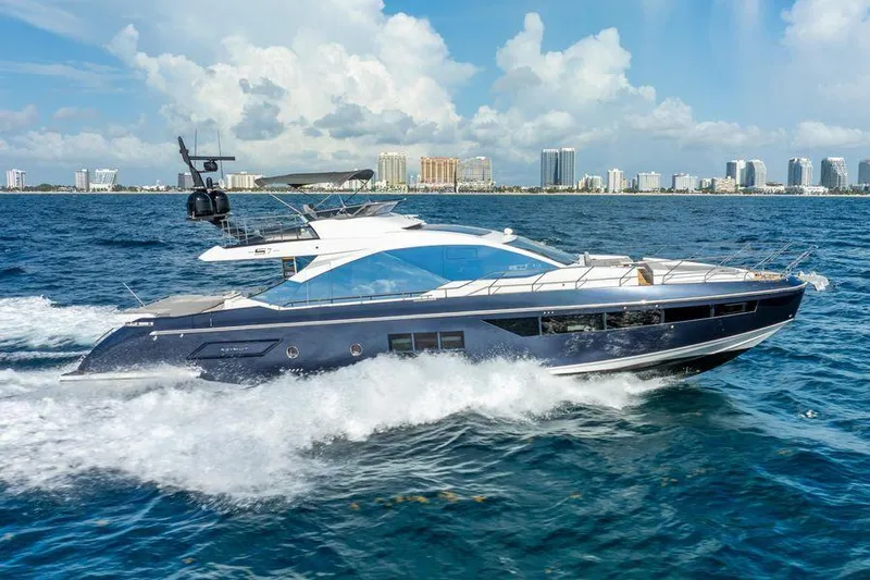  Yacht Photos Pics 2019 Azimut S7 yacht cruising on the ocean with city skyline in the background.