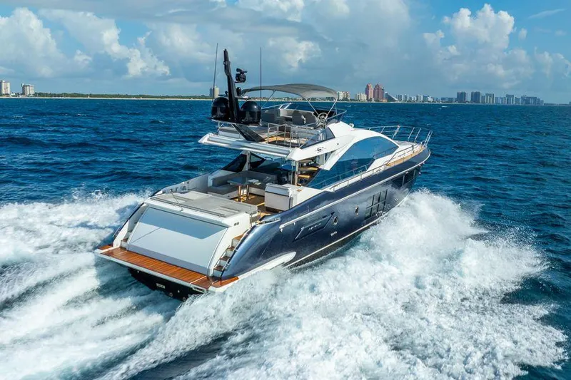  Yacht Photos Pics 2019 Azimut S7 yacht cruising on open ocean with city skyline in background.