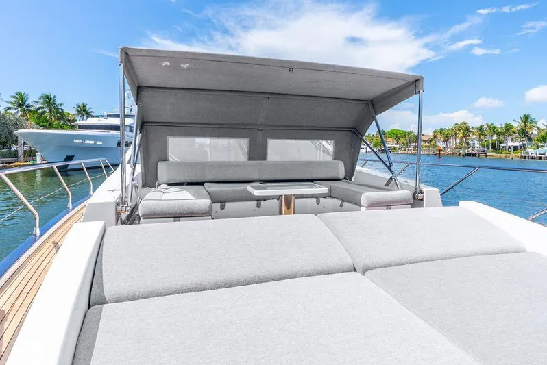  Yacht Photos Pics 2019 Azimut S7 yacht with sunbathing area and canopy, docked by palm trees and water.