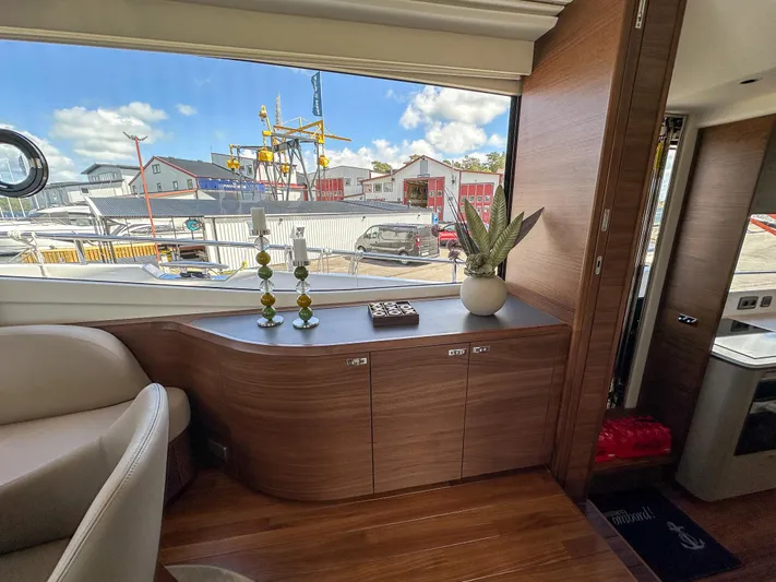 X80034 Yacht Photos Pics Luxurious interior of 2024 Princess X80 yacht with elegant wood finish and scenic marina view.
