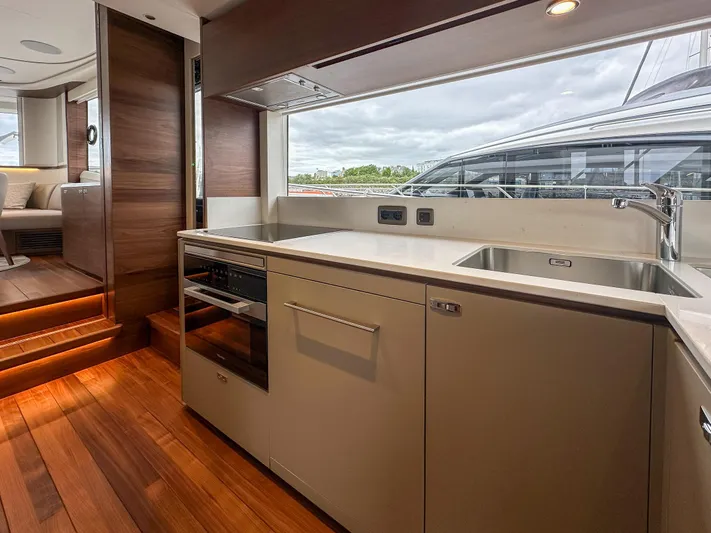 X80034 Yacht Photos Pics Luxurious kitchen interior of 2024 Princess X80 yacht with modern appliances and wooden flooring.