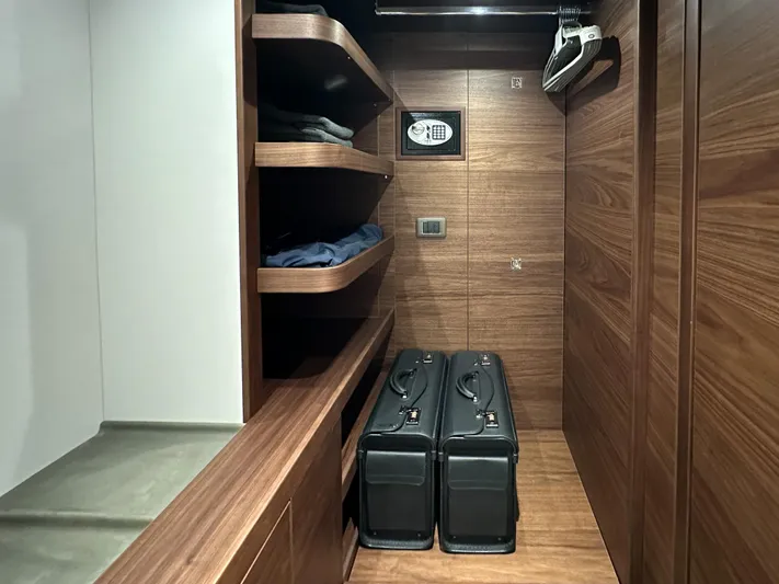X80034 Yacht Photos Pics Luxurious wooden closet in 2024 Princess X80 yacht with shelves, safe, and luggage.