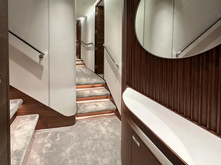 X80034 Yacht Photos Pics Luxurious interior hallway of 2024 Princess X80 yacht with elegant wood paneling and carpeted stairs.