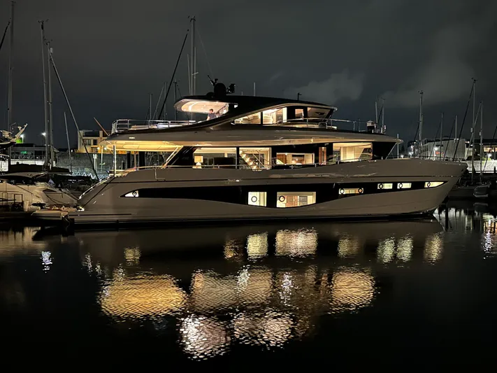 X80034 Yacht Photos Pics Luxurious 2024 Princess X80 yacht illuminated at night, reflecting on calm marina waters.