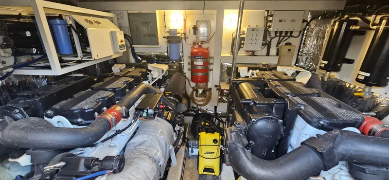  Yacht Photos Pics Engine room of a 2014 Princess 64 yacht, featuring dual engines and various mechanical components.