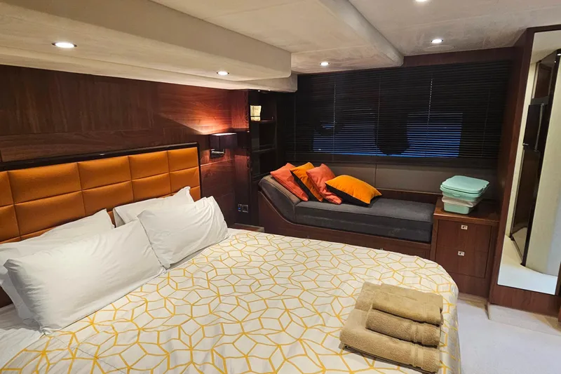  Yacht Photos Pics Luxurious bedroom interior of 2014 Princess 64 yacht with modern decor and cozy seating area.