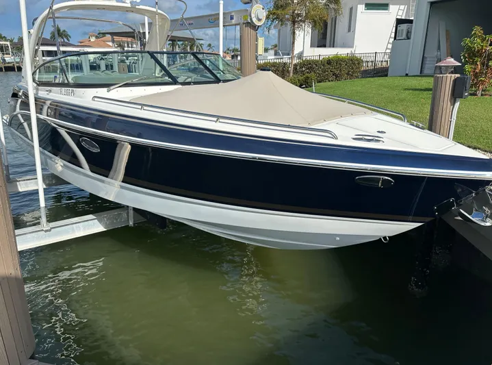  Yacht Photos Pics 2015 Formula 310 Bowrider boat docked on a lift by waterfront home.