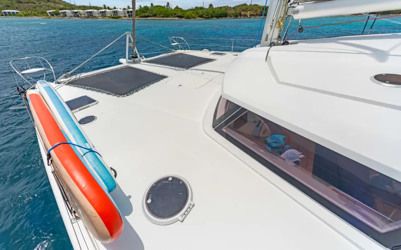 Endless Azul Yacht Photos Pics Fountaine Pajot Sanya 57 catamaran deck with paddleboards, 2013 model, anchored near tropical shoreline.