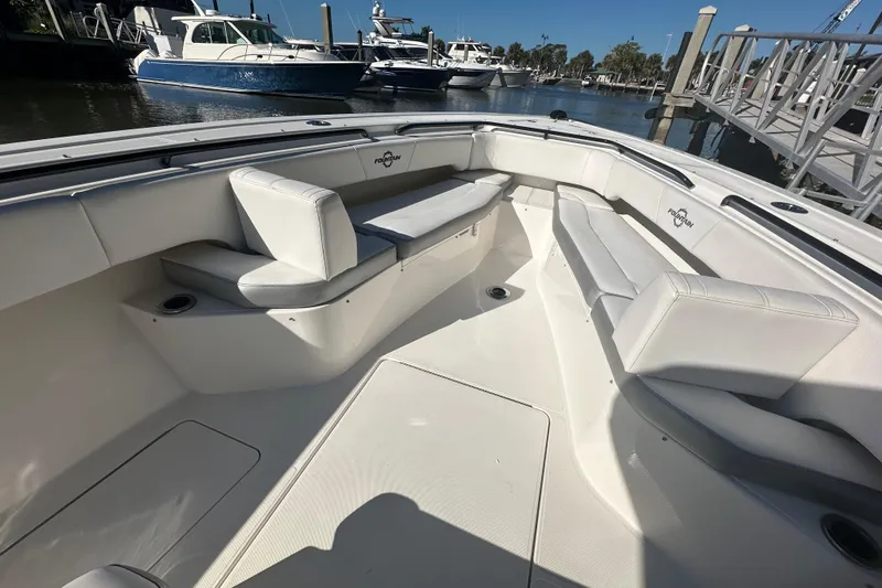  Yacht Photos Pics 2022 Fountain 38 CC LS boat interior with white seating, docked at marina.