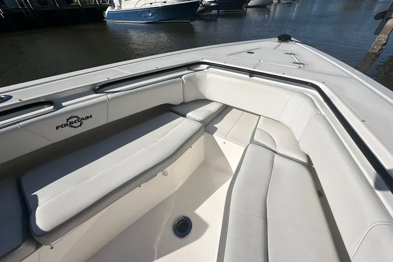 Yacht Photos Pics 2022 Fountain 38 CC LS boat with spacious seating, docked by the water.