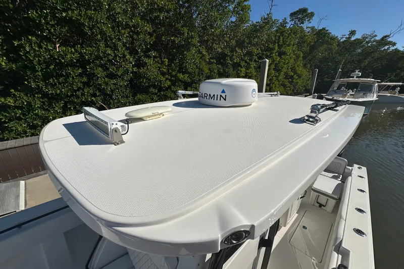  Yacht Photos Pics 2022 Fountain 38 CC LS boat with Garmin equipment, docked near lush greenery.