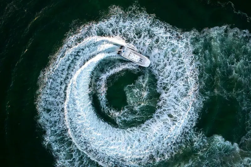  Yacht Photos Pics Aerial view of 2026 Invincible 36 Catamaran creating circular wake pattern in ocean.