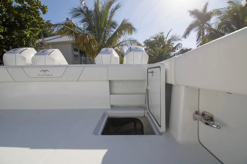  Yacht Photos Pics 2026 Invincible 36 Catamaran boat deck with storage, palm trees in background.