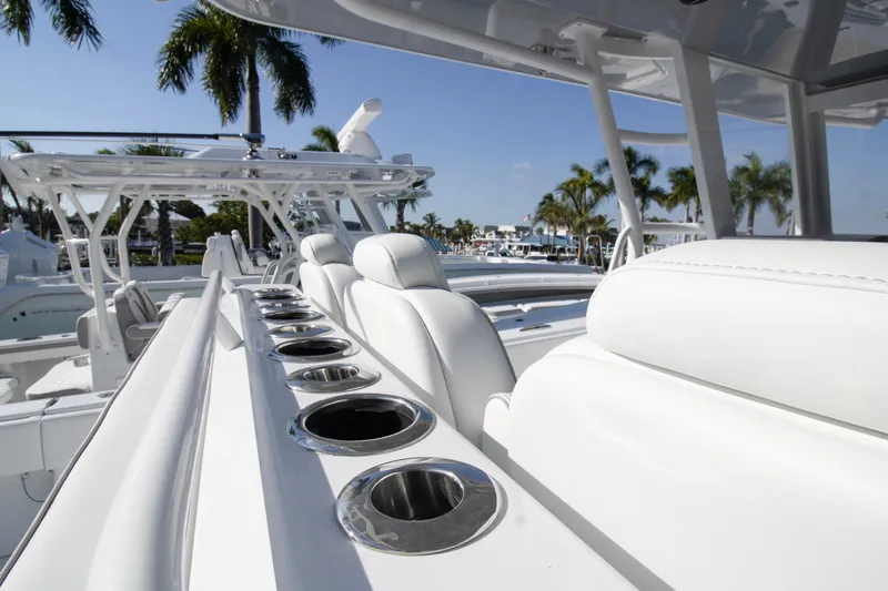  Yacht Photos Pics 2026 Invincible 36 Catamaran with sleek white seating and cup holders, docked near palm trees.