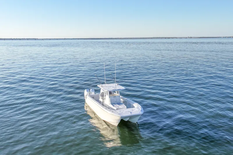  Yacht Photos Pics 2026 Invincible 36 Catamaran on calm ocean waters under clear blue sky.