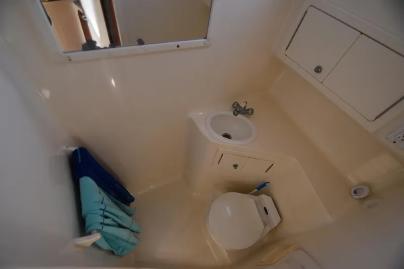 Barbara Ann Yacht Photos Pics Compact bathroom in 2001 Carolina Classic 35 Express boat, featuring sink, toilet, and storage.