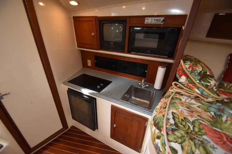 Barbara Ann Yacht Photos Pics Compact kitchen area in a 2001 Carolina Classic 35 Express boat, featuring appliances and floral decor.