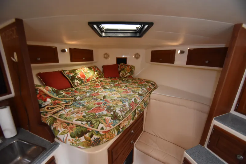 Barbara Ann Yacht Photos Pics Cozy cabin interior of 2001 Carolina Classic 35 Express with floral bedding and wood cabinets.
