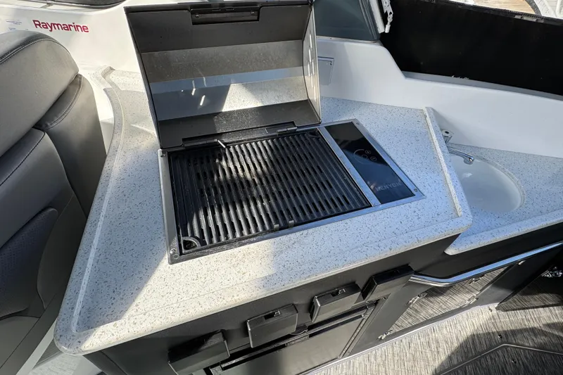  Yacht Photos Pics 2020 Rinker 320 EX boat kitchenette with grill and sink, featuring Raymarine equipment.
