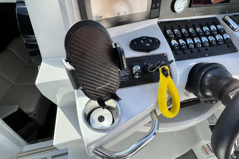  Yacht Photos Pics 2020 Rinker 320 EX helm with phone holder, controls, and yellow safety lanyard.
