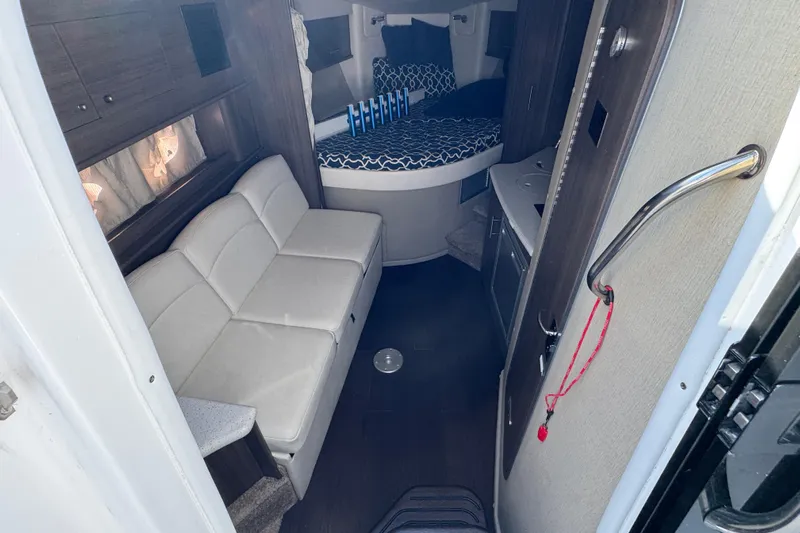  Yacht Photos Pics Interior of 2020 Rinker 320 EX boat with sofa, bed, and kitchenette.