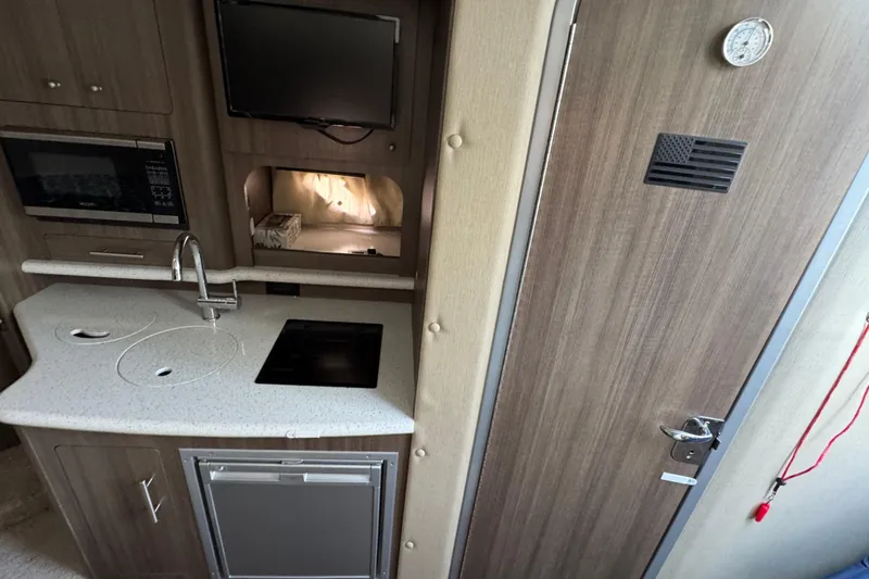  Yacht Photos Pics 2020 Rinker 320 EX boat interior with kitchenette, microwave, and modern design.