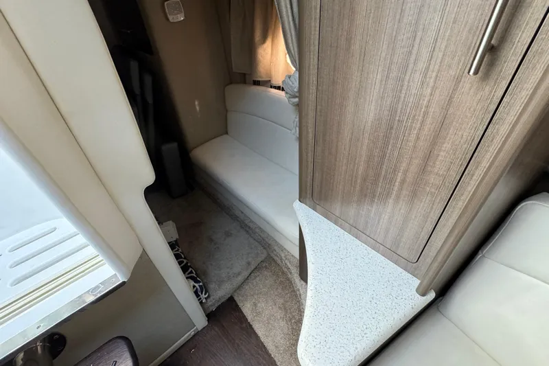  Yacht Photos Pics Interior of a 2020 Rinker 320 EX boat, featuring seating and wood cabinetry.