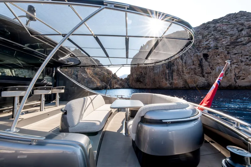 Loloma Yacht Photos Pics Luxurious 2025 Zeelander 7 yacht with elegant seating, scenic ocean view, and rocky cliffs.