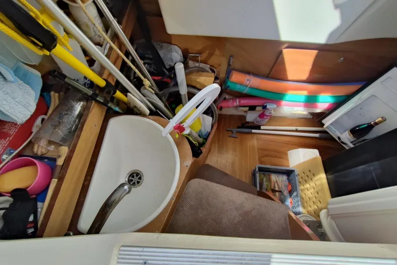  Yacht Photos Pics Cluttered storage area in a 2007 Prestige 46 boat with various items and a sink.