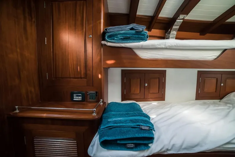 Spirit R74 Yacht Photos Pics Luxurious wooden cabin interior with bunk beds and teal towels, Spirit R74, 2014 model.
