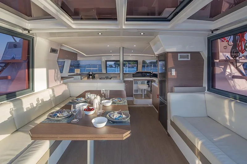  Yacht Photos Pics Luxurious interior of 2020 Bali 4.1 catamaran with elegant dining setup and panoramic windows.