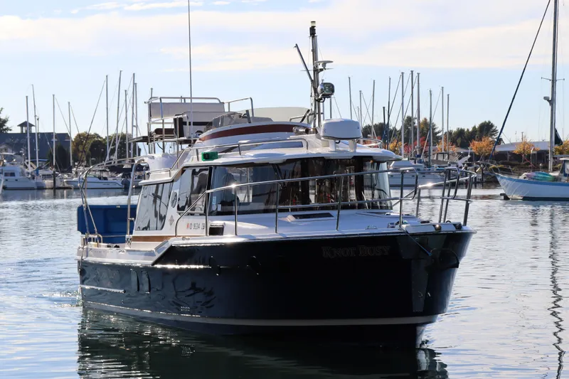 Knot Busy Yacht Photos Pics 2017 Ranger Tugs R-29 CB boat cruising in a marina with sailboats in the background.