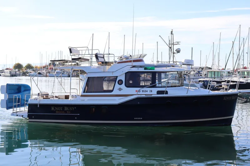 Knot Busy Yacht Photos Pics 2017 Ranger Tugs R-29 CB boat docked in a marina, reflecting on calm water.