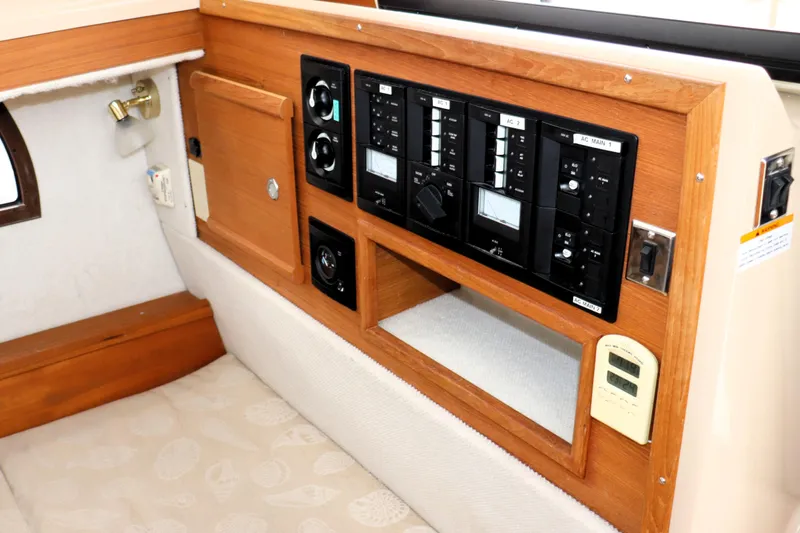Knot Busy Yacht Photos Pics 2017 Ranger Tugs R-29 CB interior control panel with wood finish and seating area.