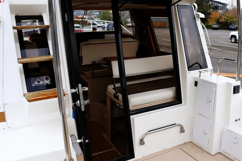 Knot Busy Yacht Photos Pics 2017 Ranger Tugs R-29 CB interior view with open door and seating area.