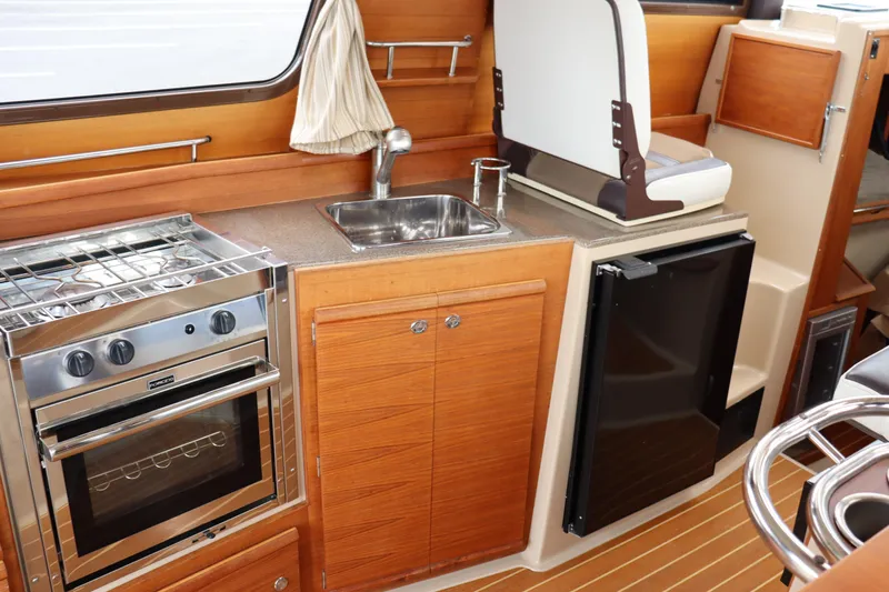 Knot Busy Yacht Photos Pics 2017 Ranger Tugs R-29 CB galley with stove, sink, and compact refrigerator.
