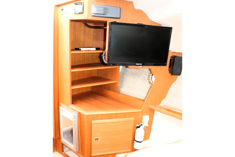 Knot Busy Yacht Photos Pics 2017 Ranger Tugs R-29 CB interior with TV, shelves, and fire extinguisher.