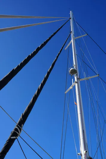 Topdog Yacht Photos Pics Mast of 2018 Lagoon 560 S2 sailboat against clear blue sky.
