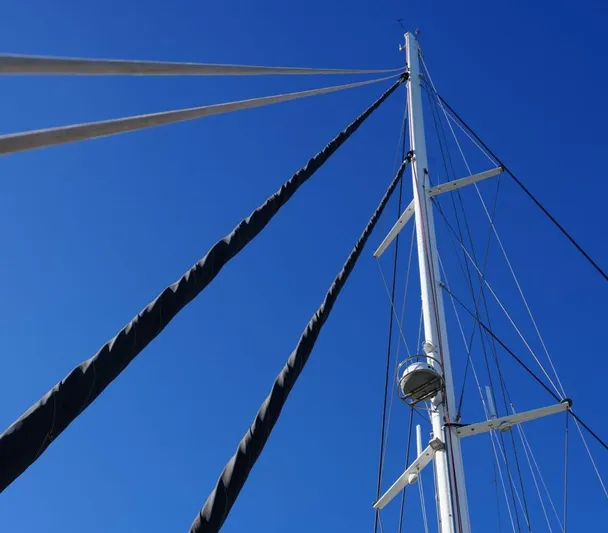 Topdog Yacht Photos Pics Mast of 2018 Lagoon 560 S2 sailboat against clear blue sky.