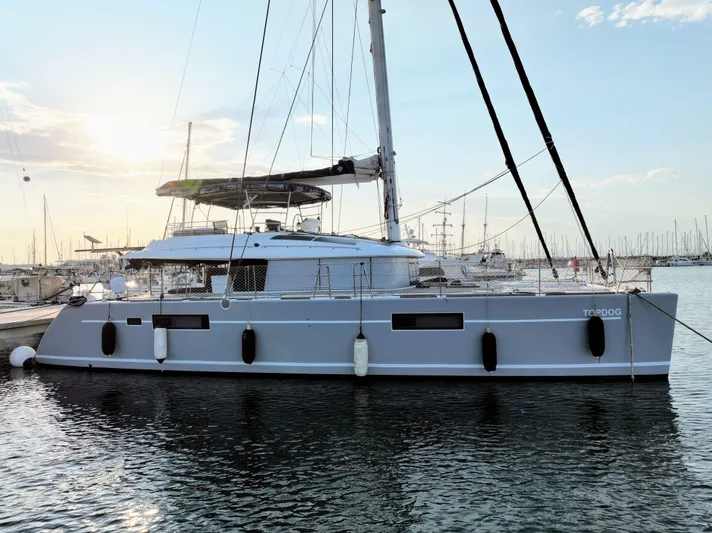 Topdog Yacht Photos Pics 2018 Lagoon 560 S2 catamaran docked at sunset in a marina.