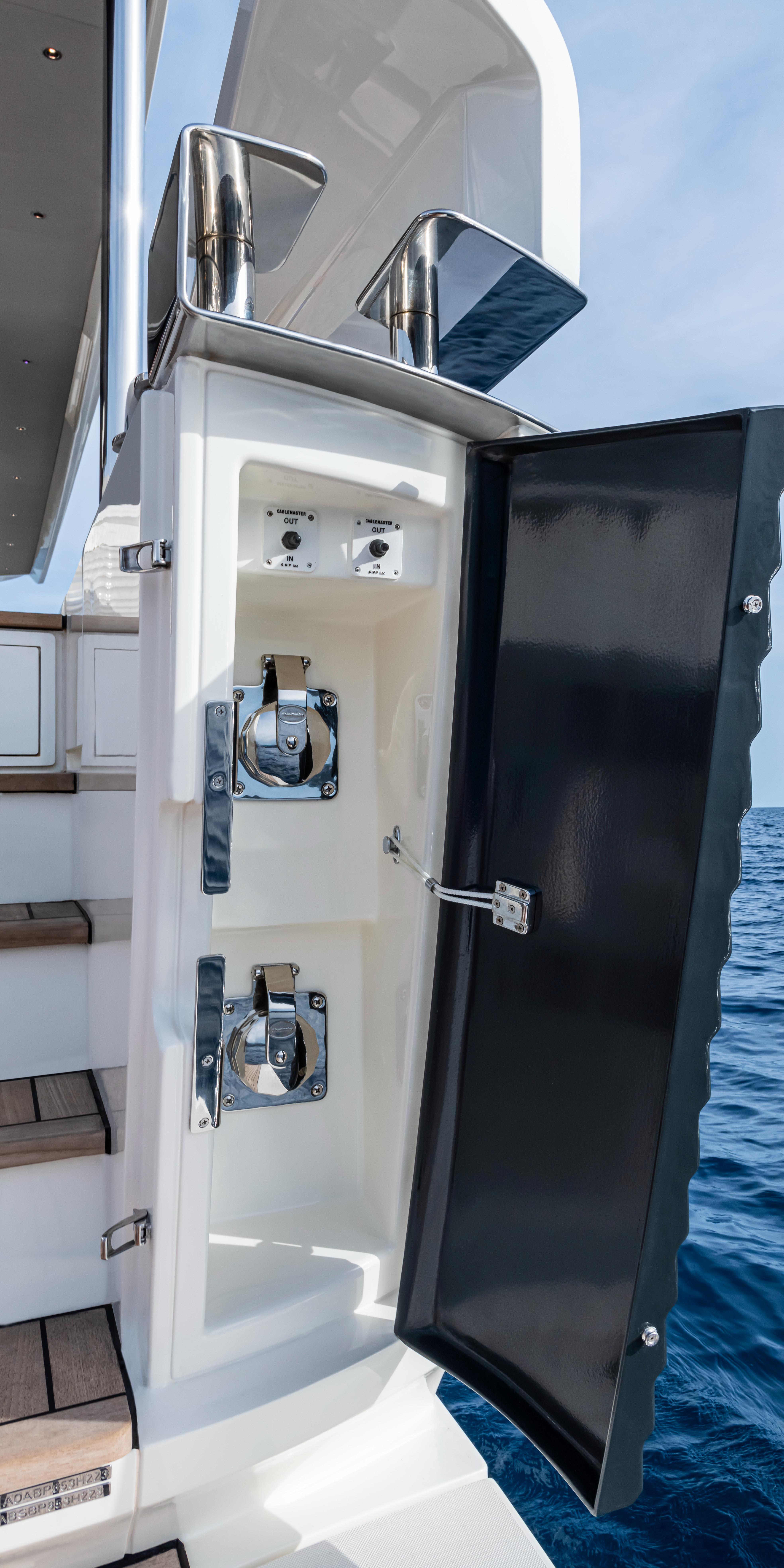 2025 Absolute NAVETTA 75 yacht detail with open storage compartment by the sea.