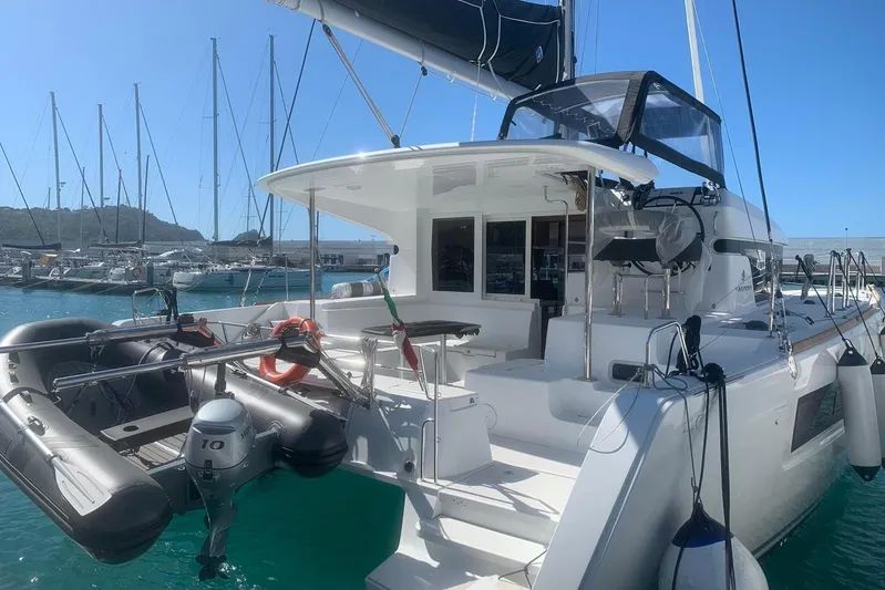  Yacht Photos Pics 2020 Lagoon 40 catamaran docked in marina, featuring inflatable dinghy and clear blue sky.