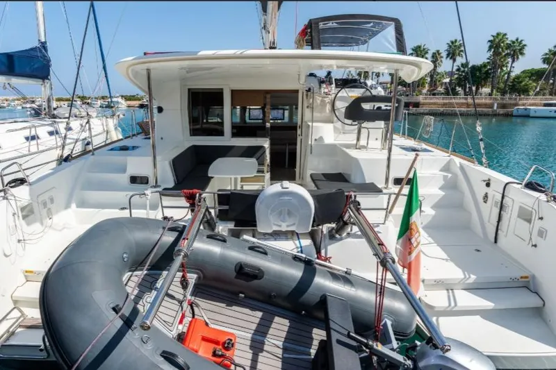  Yacht Photos Pics 2020 Lagoon 40 catamaran with spacious deck, inflatable boat, and scenic marina backdrop.