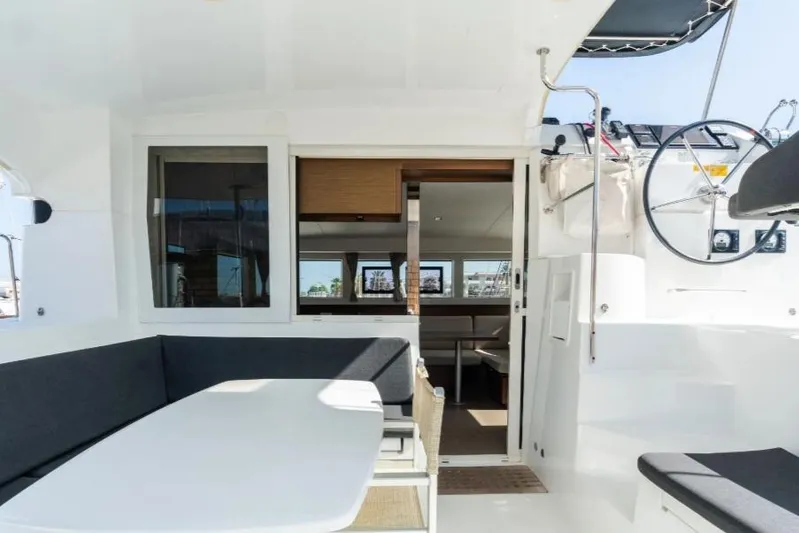  Yacht Photos Pics 2020 Lagoon 40 catamaran interior with seating area and helm, showcasing modern design.