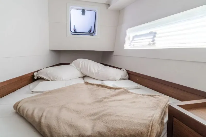  Yacht Photos Pics Cozy cabin interior of 2020 Lagoon 40 catamaran with bed and window.