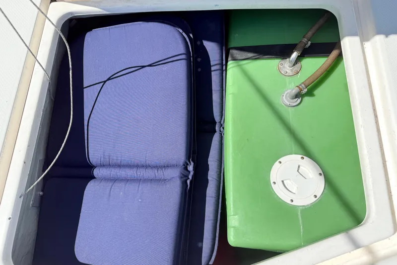 Selah Yacht Photos Pics Storage compartment on a 2010 Leopard 38 boat with cushions and green tank.