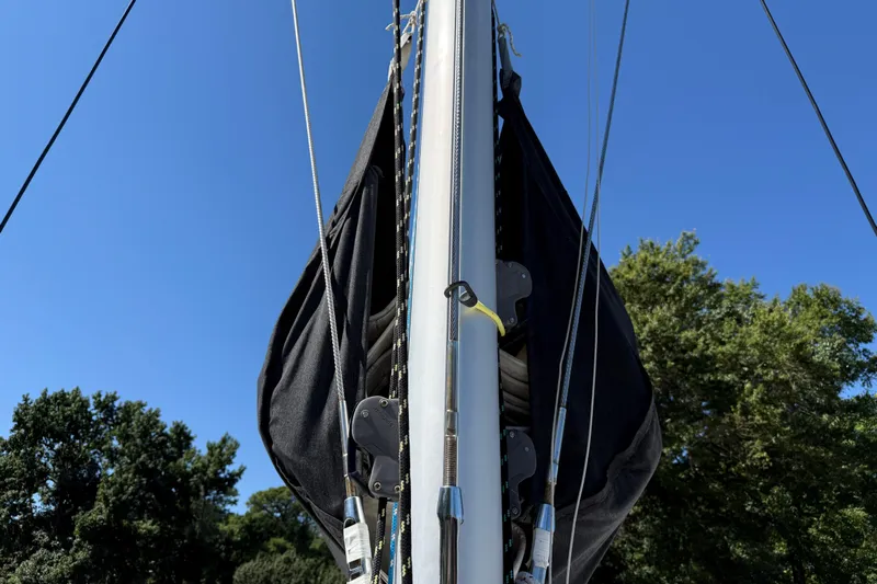 Selah Yacht Photos Pics Mast of 2010 Leopard 38 sailboat against clear blue sky and trees.