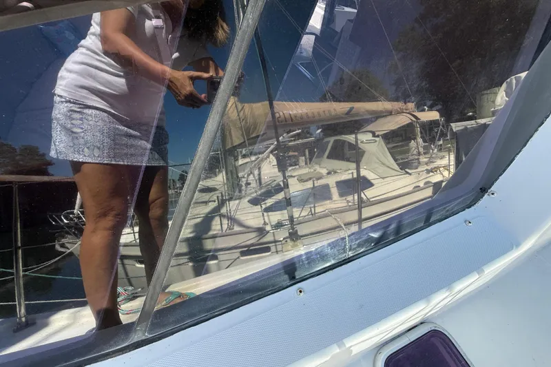 Selah Yacht Photos Pics Reflection on Leopard 38 sailboat window, showing a person taking a photo, 2010 model.